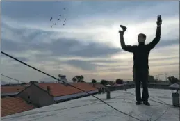  ?? PHOTOS PROVIDED TO CHINA DAILY ?? Colin Chinnery records pigeon whistles on top of a building in Beijing.