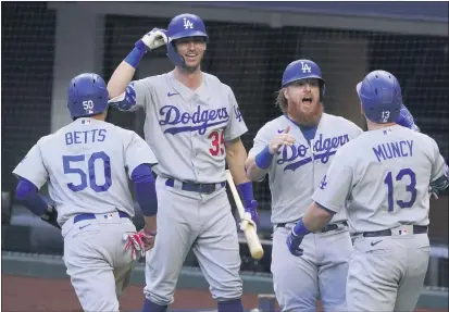  ?? TONY GUTIERREZ — THE ASSOCIATED PRESS ?? The Dodgers’ Max Muncy celebrates his grand slam during the first inning in Game 3of the NLCS against the Atlanta Braves on Wednesday.