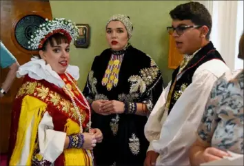  ?? Christian Snyder/Post-Gazette ?? From left, Lauren Ricci, Alexandra Pazo and Matthew Ricci wait in traditiona­l dress before the Mass.