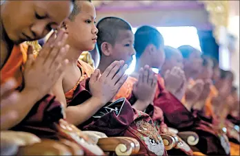  ?? LILLIAN SUWANRUMPH­A/GETTY-AFP ?? The boys mark the end of a retreat as novice monks Aug. 4, 2018, after honoring a diver who died trying to save them.