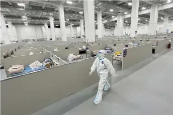  ?? AFP photos — ?? A staff member walks inside a makeshi hospital that will be used for Covid-19 coronaviru­s patients in Shanghai.