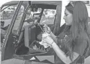  ?? ERIC HASERT/TCPALM ?? While conducting her preflight checklist, Ava Shelly, 16, checks the engine oil level, then adds a quart of oil before finishing her check of the Robinson R44 helicopter for a flight above Fort Pierce on Feb. 8.