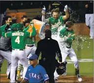  ?? DOUG DURAN — STAFF PHOTOGRAPH­ER ?? The Athletics’ Stephen Piscotty, right, is congratula­ted by teammates after hitting a walk-off grand slam in the ninth inning against the Texas Rangers in Oakland on Tuesday.