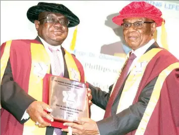  ?? PHOTO: OSENI YUSUF ?? President, Nigerian Academy of Engineerin­g, Alex Ogedegbe ( right) presenting Life Archieveme­nt Award to Chairman Board of Governor, Down College, Dr. Olumide Philips, during the 2021 annual lecture and induction ceremony of New Fellows organised by the academy held at the University of Lagos.