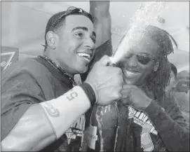  ??  ?? Athletics’ Yoenis Cespedes, left, and Jemile Weeks spray champagne as the A’s celebrate in the clubhouse after their 12-5 win over the Texas Rangers Wednesday, clinching the AL West title.