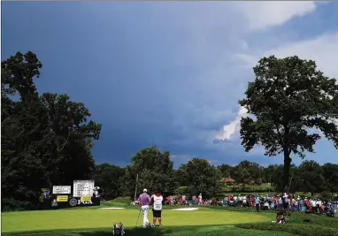  ?? JAMIE SQUIRE / GETTY IMAGES ?? It was a record day of scoring Friday at Bellerive Country Club in St Louis — until the skies darkened and dangerous weather stopped play. Tiger Woods and Rickie Fowler are among the golfers who will finish Round 2 today.