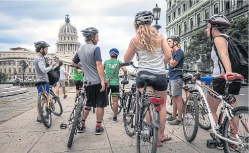  ?? PHOTOS BY AFP ?? ABOVE Tourists take a bicycle tour in Havana.