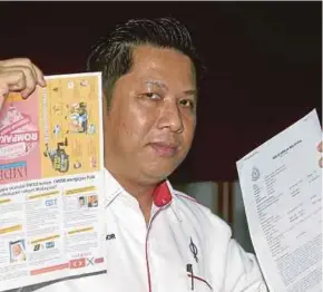  ?? PIC BY ROSDAN WAHID ?? DAP member Amran Ahmad holding his party’s slanderous pamphlets and a police report at a press conference at the Bukit Aman police headquarte­rs yesterday.