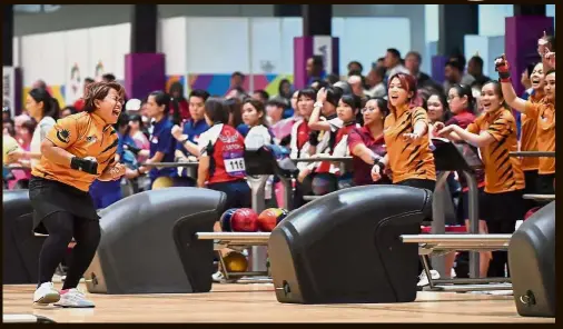  ??  ?? Rolling with the punches: Malaysian bowler Shalin Zulkifli (left) rejoicing after a strike in the women’s teamof-six clash with South Korea at the Indonesia Asian Games in Palembang yesterday. — Bernama