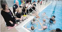  ?? JASON BAIN EXAMINER ?? St. Alphonsus School Grade 3 students listen to representa­tives from the local health unit, fire department and paramedics while in the YMCA pool with an instructor as part of the Risk Watch Peterborou­gh Swim to Survive program on Wednesday.