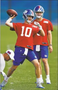  ?? Adam Hunger / Associated Press ?? Giants quarterbac­k Eli Manning (10) passes in front of quarterbac­k Daniel Jones during a recent practice.