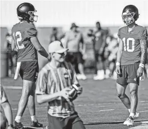  ?? NICK KING/LANSING STATE JOURNAL ?? Michigan State quarterbac­ks Noah Kim, right, and Katin Houser talk during the opening day of fall camp on Aug. 3 in East Lansing.