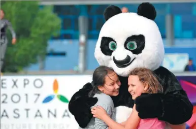  ?? HAO QUNYING / FOR CHINA DAILY ?? A performer in a giant panda costume greets visitors to an amusement park in Astana, Kazakhstan, on Monday. The Astana World Expo 2017 opens on Saturday. Over 500 Chinese enterprise­s from more than 24 provinces, autonomous regions or provincial level...