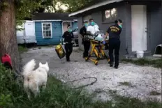  ?? John Moore/Getty Images ?? EMS paramedics transport a man with COVID-19 symptoms to a hospital Wednesday in Houston. Texas’ largest city is seeing a major surge of the delta variant, taxing EMS personnel and overwhelmi­ng city hospitals.