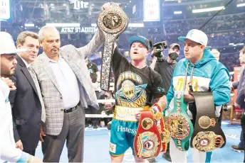  ?? — AFP photos ?? Mexican boxer Saul “Canelo” Alvarez (C) celebrates after defeating British boxer Billy Joe Saunders during their super middleweig­ht title fight at the AT&T Stadium in Arlington, Texas.