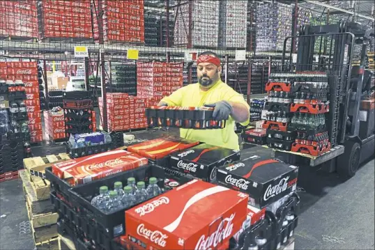  ?? Nate Guidry/Post-Gazette photos ?? John Elsbury of Marianna sorts Coca-Cola products at a facility in Houston, Washington County. Abarta is expanding is beverage business.