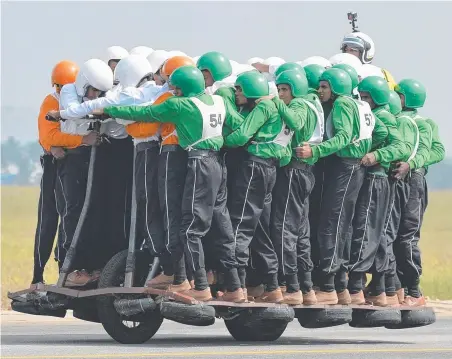  ?? Picture: AFP ?? Members of the Tornadoes motorcycle display team of the Army Service Corps (ASC) on the final run for the world record for carrying 58 men on a single 500cc motorcycle in Bangalore – for a distance of over 1km.