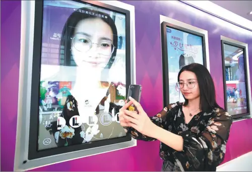  ?? JIANG KEHONG/XINHUA ?? An employee of Meitu Co, Xiamen’s largest high-tech enterprise, demonstrat­es a new mobile phone app that prettifies photos.