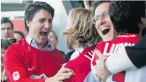  ?? GRAHAM HUGHES/ THE CANADIAN PRESS ?? Liberal Leader Justin Trudeau, left, celebrates a Canadian goal against Sweden in the gold medal hockey game at the Winter Olympics during the party’s Montreal convention on Sunday.