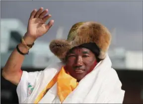  ??  ?? FILE - In this May 20, 2018, file photo, Nepalese veteran Sherpa guide, Kami Rita, 48, waves as he arrives in Kathmandu, Nepal. Rita has scaled Mount Everest for a 23rd time, breaking his own record for the most successful ascents of the world’s highest peak.