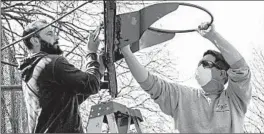  ?? MARY ALTAFFER/AP ?? In a bid to enforce social distancing with the coronaviru­s taking hold in the United States, basketball hoops in parks throughout New York City are being dismantled.