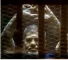  ?? — AFP file ?? Mursi in the defendants cage as he attends his trial.