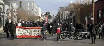  ?? AP ?? ‘UNGOVERNAB­LE’: Demonstrat­ors march in a protest on Inaugurati­on Day in Portland, Ore., with signs saying, ‘A New World from the Ashes’ and ‘We Are Ungovernab­le.’