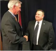 ?? ERIC DEVLIN — DIGITAL FIRST MEDIA ?? John Becker, a former sergeant of the Hatboro Police Department and 17-year police force veteran, shakes hands with Montgomery County District Attorney Kevin Steele during a press conference Wednesday about a grand jury report on the opioid crisis....