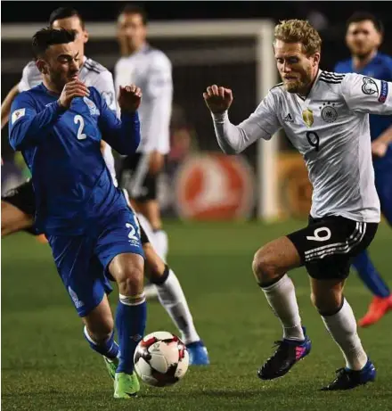  ?? AFP PIC ?? Azerbaijan’s Gara Garayev (left) and Germany’s Andre Schuerrle vie for the ball in their World Cup qualifier on Sunday. Germany won 4-1.