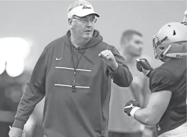  ?? PHOTOS BY PHIL MASTURZO/AKRON BEACON JOURNAL ?? Akron coach Joe Moorhead fist-bumps linebacker Bubba Arslanian during the team’s spring game on April 30.