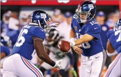  ?? JOHN BLAINE — FOR THE TRENTONIAN ?? Giants quarterbac­k Eli Manning (10) hands the ball off to running back Orleans Darkwa (26) during a Week 7 game against the Seattle Seahawks.