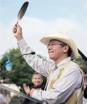  ?? DARRYL DYCK / THE CANADIAN PRESS ?? Coldwater Indian band Chief Lee Spahan raises an eagle feather at a news conference in Vancouver on Thursday responding to a Federal Court of Appeal ruling on the Kinder Morgan Trans Mountain Pipeline expansion.