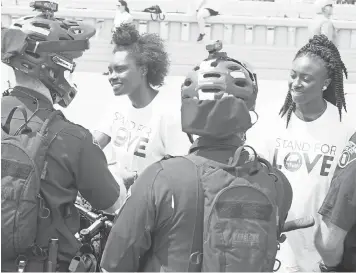  ?? TREVOR HUGHES, USA TODAY ?? Hannah Givens, 16, and sister Amanda, 18, greet officers Sunday after a silent vigil in Cleveland.