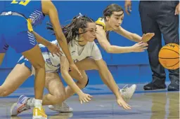  ?? PHOTOS BY LUIS SÁNCHEZ SATURNO THE NEW MEXICAN ?? LEFT: St. Michael’s Jada Lujan, center, and Cuba’s Magdalena Gauna-Casaus, left, dive for a loose ball during the fourth quarter Friday in Perez-Shelley Gymnasium. The Lady Horsemen won 56-31.