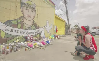  ?? STEVE GONZALES/HOUSTON CHRONICLE VIA AP ?? Dawn Gomez holds her 3-year-old granddaugh­ter, Saryia Greer, who waves Thursday at Vanessa Guillen’s mural painted on the side of a building in Houston, Texas.