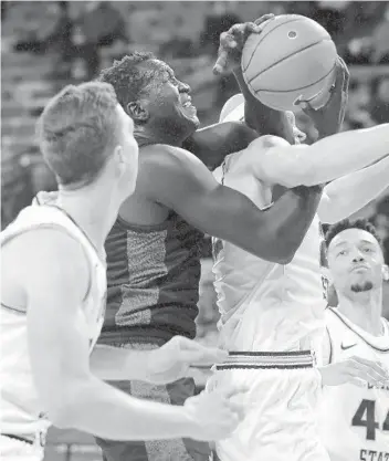  ?? ELI LUCERO THE HERALD JOURNAL VIA AP ?? Aztecs forward Aguek Arop (left) fights for a rebound against Utah State’s Brock Miller in the second half.