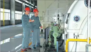  ?? TO CHINA DAILY PHOTOS PROVIDED ?? Engineers at China Huadian Engineerin­g Co Ltd examine a machine. The CHEC has always considered how to use modern technologi­cal ideas in its management and operations.