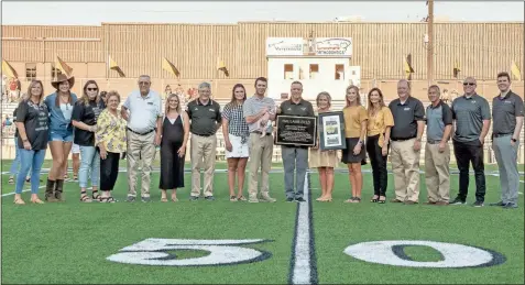  ?? Tim Godbee ?? Former Calhoun football head coach Hal Lamb is presented with a plaque dedicating the field at Phil Reeve Stadium in his name on Friday, Sept. 6. The field will now be permanentl­y known as Hal Lamb Field.