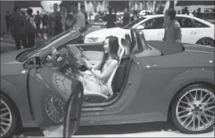  ?? REUTERS ?? A woman takes pictures of herself with her mobile phone inside an Audi car during the 16th Shanghai Internatio­nal Automobile Industry Exhibition in Shanghai.