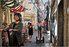  ?? — AFP ?? Taking in the city: Tourists riding ‘Segways’ to visit the streets of Alfama neighbourh­ood in lisbon.