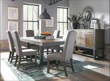  ?? Parson chairs paired with a dining table from Scott Living’s Atwater Collection has a bourbon wire-brushed finish and metal apron. ??