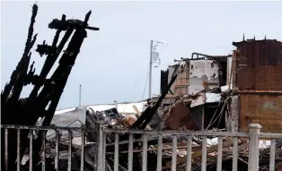  ??  ?? A low-cost housing complex burned to the ground on Thursday, leaving about 20 people homeless when the storm hit. The storm cut off residents of the archipelag­o from the rest of the province.