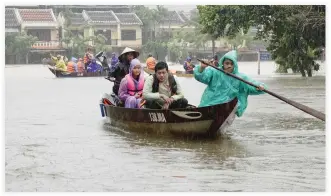  ??  ?? Residents and tourists are transporte­d by boats through floodwater­s in the tourist town of Hoi An on Sunday, one day after Typhoon Damrey made landfall in central Vietnam. (AFP)
