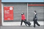  ?? RUI VIEIRA — THE ASSOCIATED PRESS FILE ?? On June 30, people walk past a closed shop in Leicester’s city center in England.