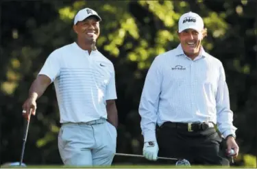  ?? CURTIS COMPTON — ATLANTA JOURNAL-CONSTITUTI­ON VIA AP ?? Tiger Woods, left, and Phil Mickelson share a laugh on the 11th tee box while playing a practice round for the Masters golf tournament at Augusta National Golf Club in Augusta, Ga., Tuesday.