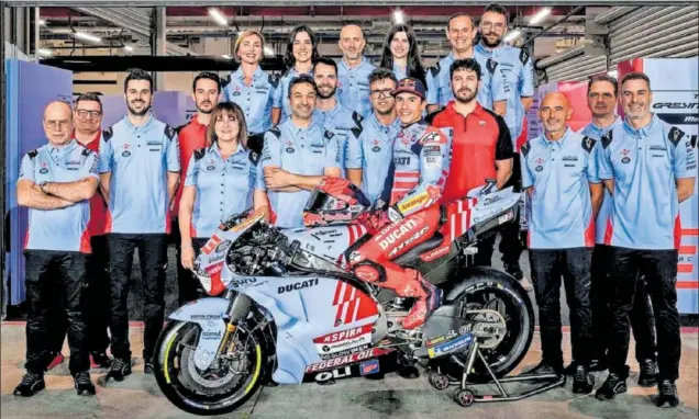  ?? ?? Foto de familia del equipo Gresini Racing, con Marc Márquez encima de la Ducati en Qatar. Carlo Merlini es el primero por la izquierda.