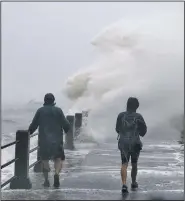  ?? AP/MIC SMITH ?? Pedestrian­s walk toward huge waves crashing over The Battery as Irma hits Charleston, S.C., on Monday.