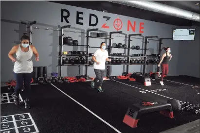  ?? Ned Gerard / Hearst Connecticu­t Media ?? RedZone members work out at a new fitness center in Weston, adhering to mask and distance rules in effect under Connecticu­t’s “2.1” safeguards to limit any transmissi­on of COVID-19.