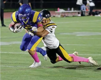  ?? STuART cAHiLL / HeRALd sTAff ?? NOT GETTING AWAY: East Boston’s Randy Bermudez is taken down by Latin Academy’s Lucas Suazo Rodriguez at East Boston Memorial Stadium on Friday night.