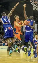  ?? PHOTO: PHOTOSPORT ?? Southland’s Reuben Te Rangi gets past two Saints defenders during the NBL match in Wellington last night.